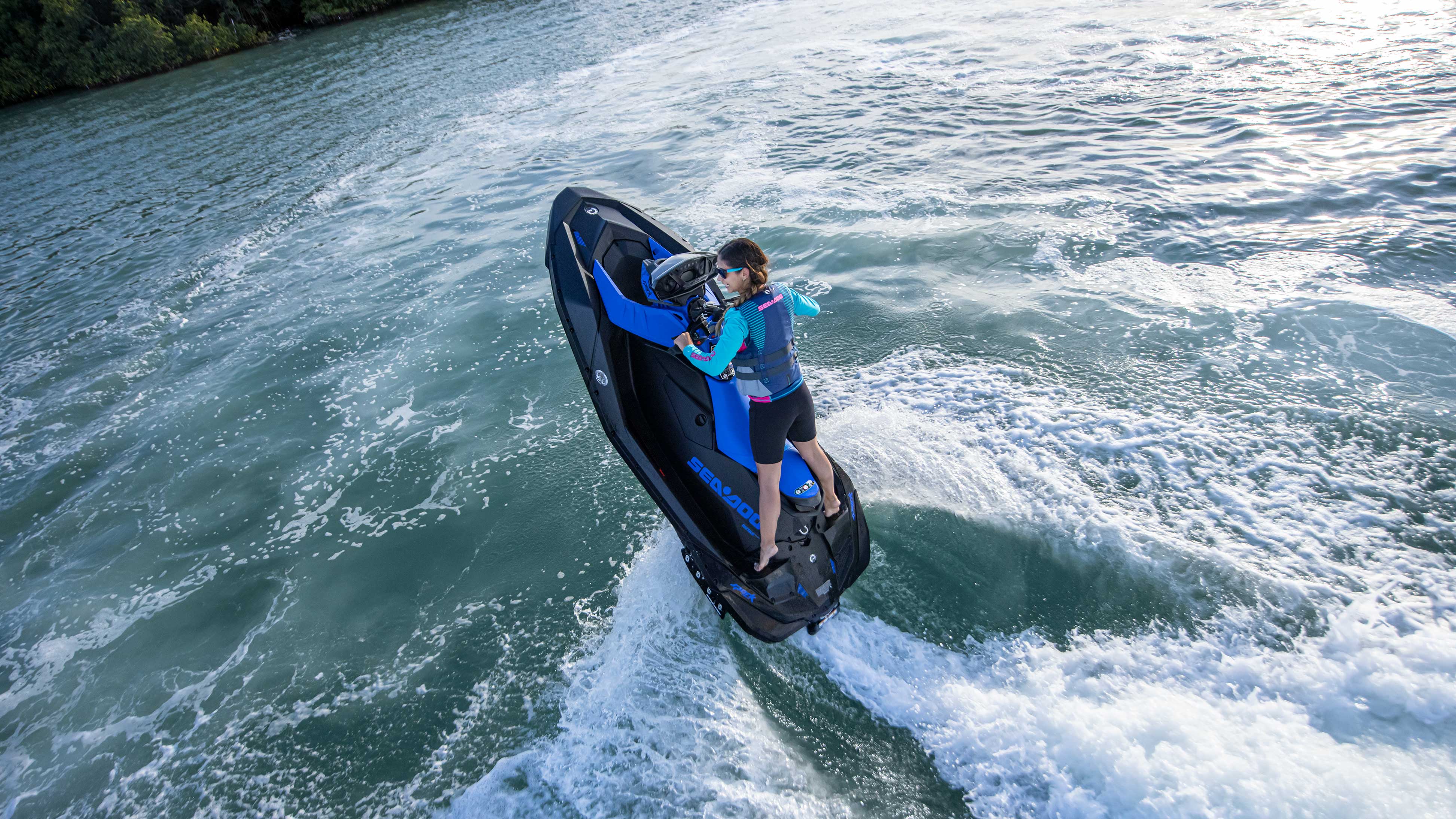 Woman doing a candle on her blue Sea-Doo SPARK TRIXX
